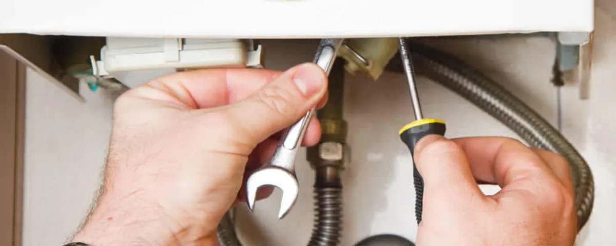 Boiler repair technician tightening pipe fittings and connections in Tucson, AZ