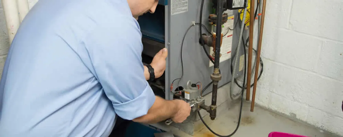 Furnace repair technician inspecting and servicing a home heating system in Tucson, AZ
